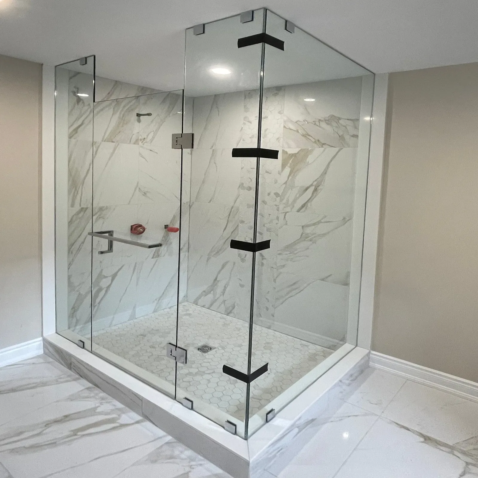 Large frameless corner shower enclosure with black clamps and hinges