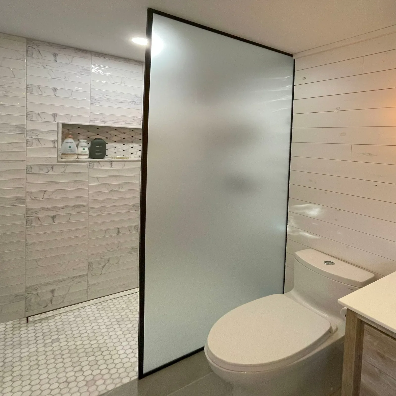 Frosted glass shower panel with a black edge frame