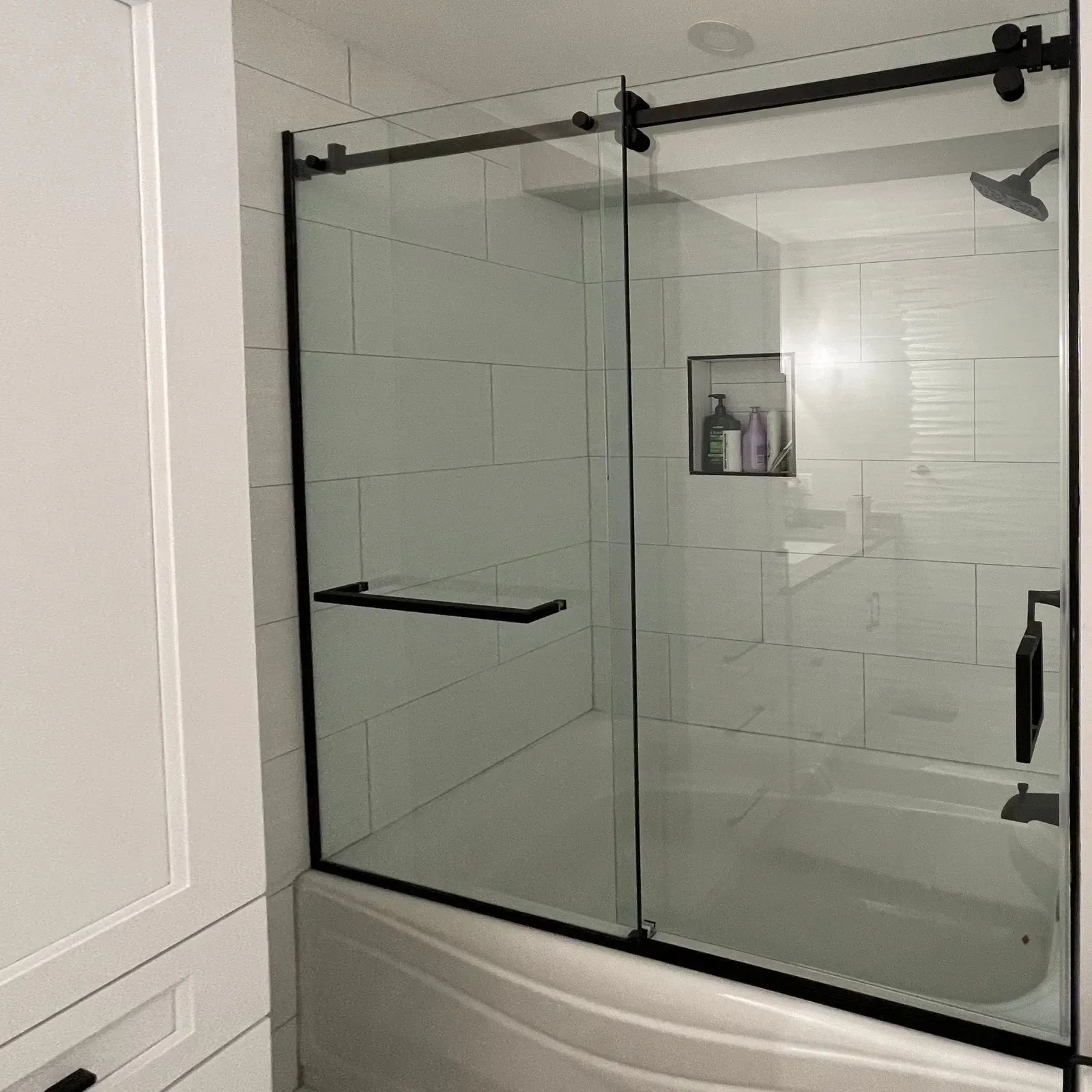 Black-framed sliding glass door on a bathtub