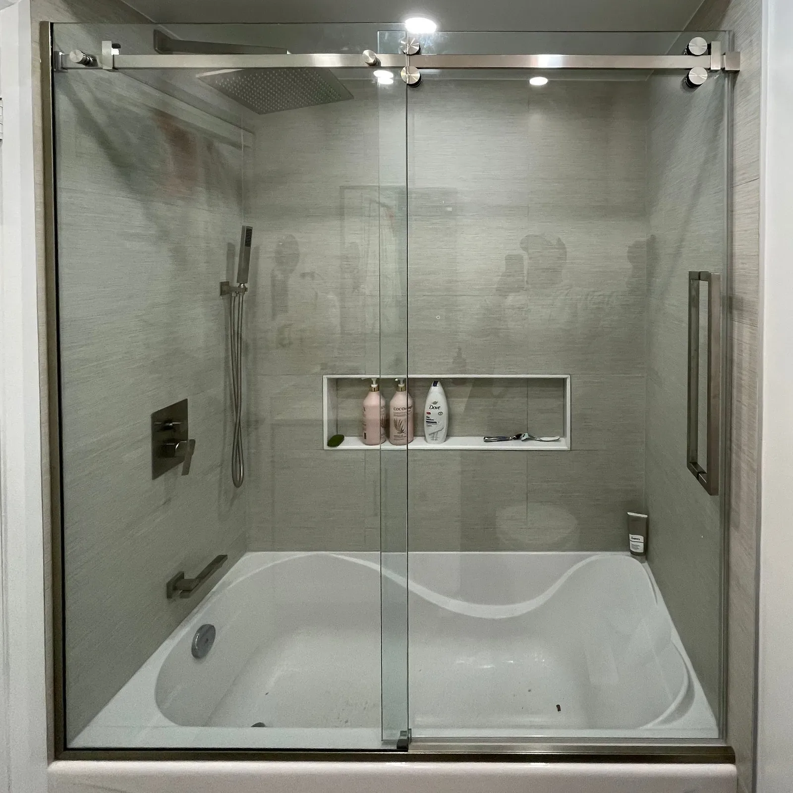 Sliding glass doors with brushed-nickel hardware over a bathtub