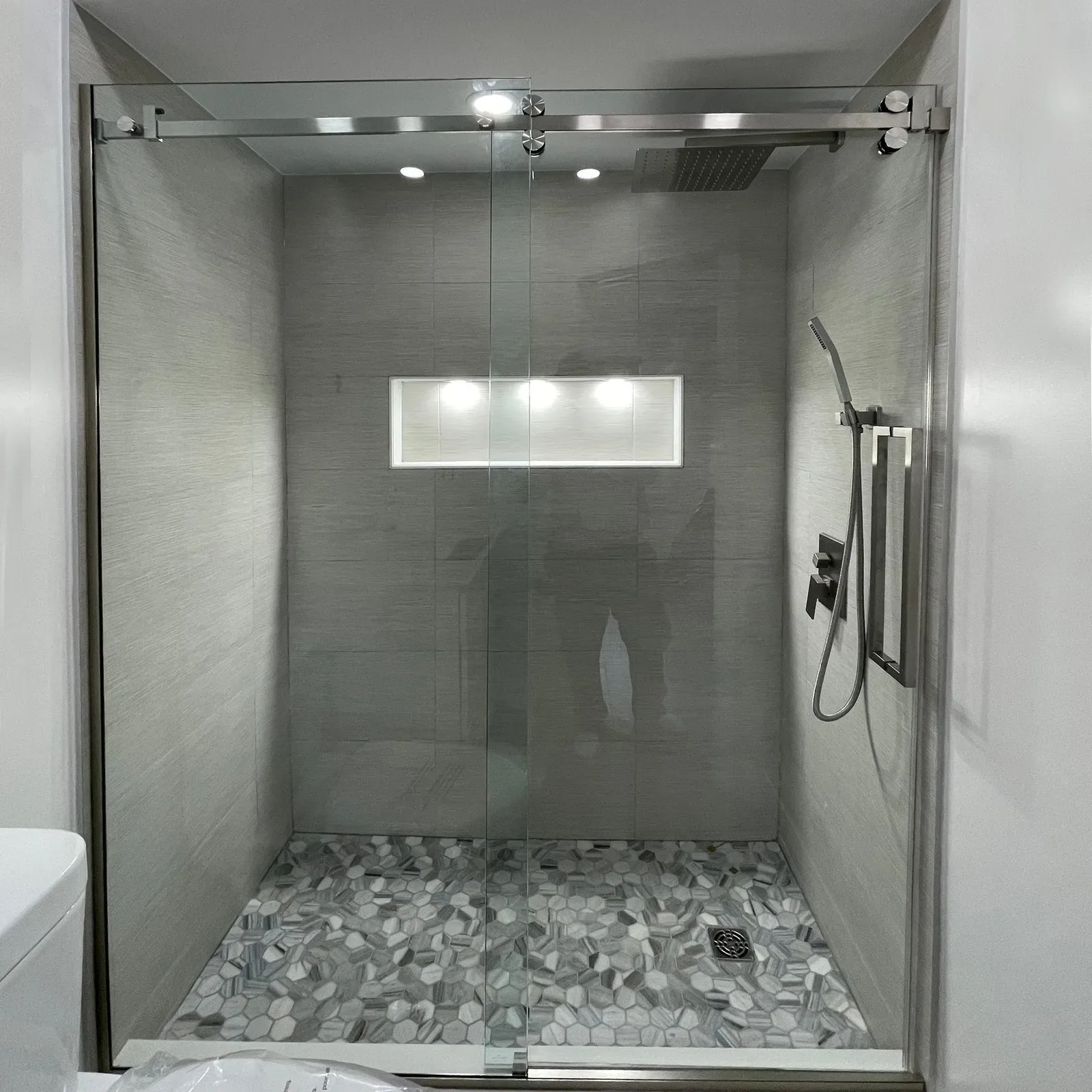 Sliding glass shower door on a tiled walk-in shower